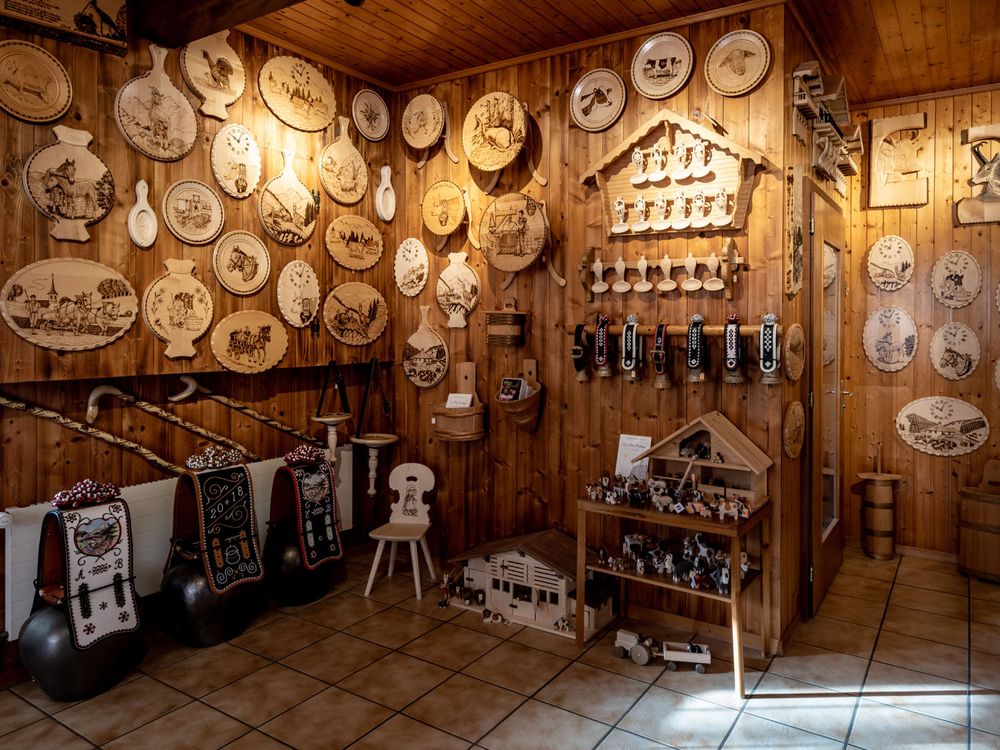 Au magasin, un mur de plateaux et d'objets pyrogravés et peints